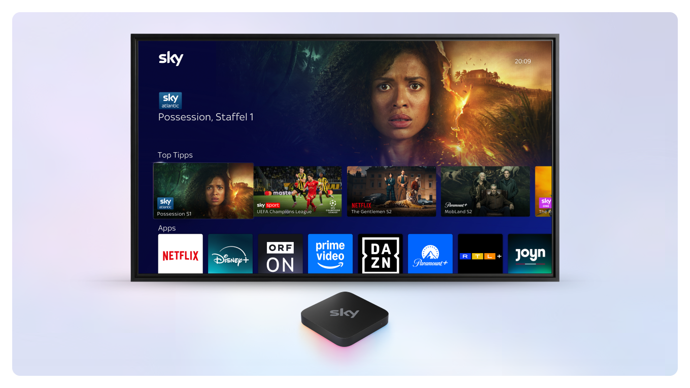 Sky Stream Box vor einem Fernseher, auf dem das Sky Stream UI zu sehen ist.